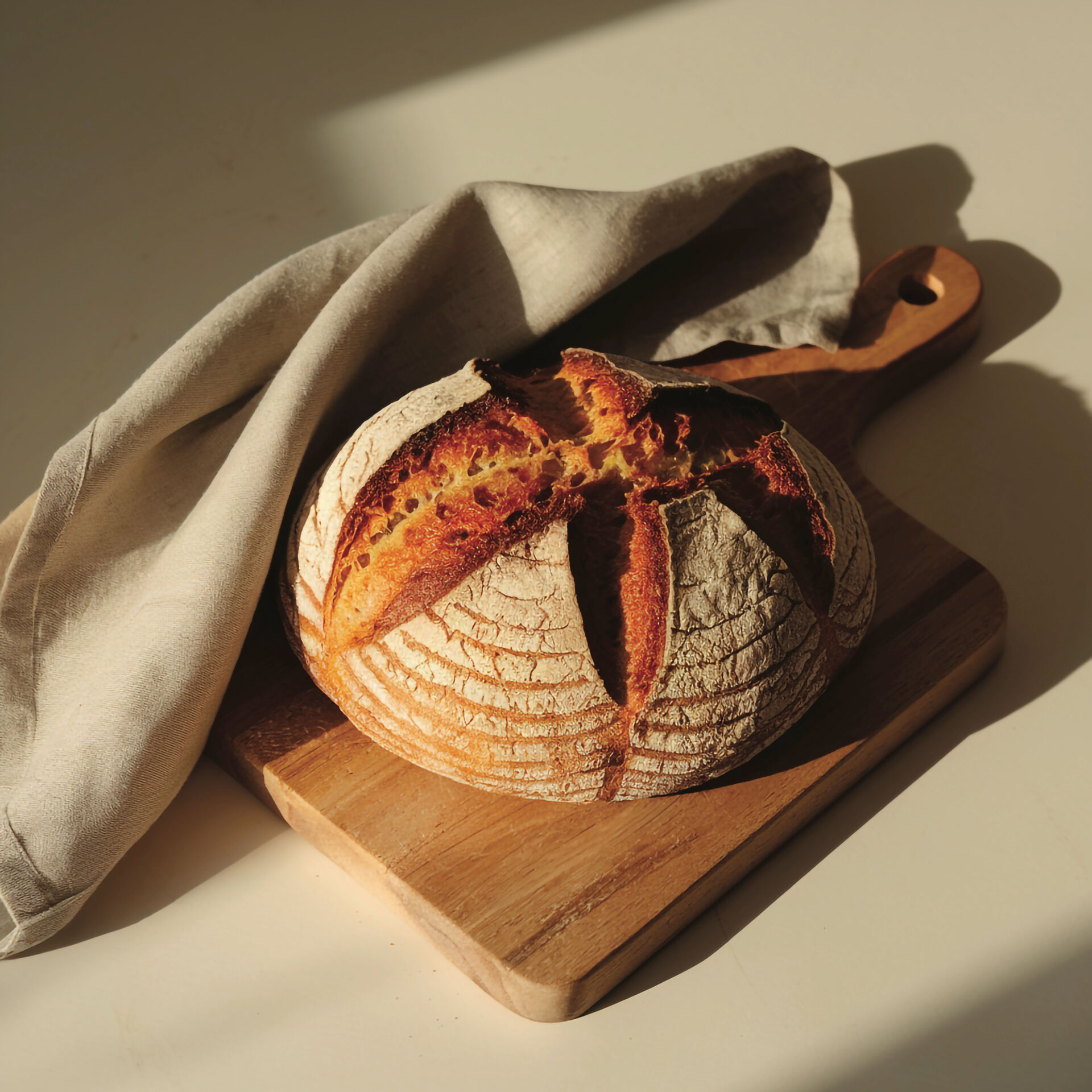 Pagnotta rustica Par Baked su tagliere di legno con canovaccio