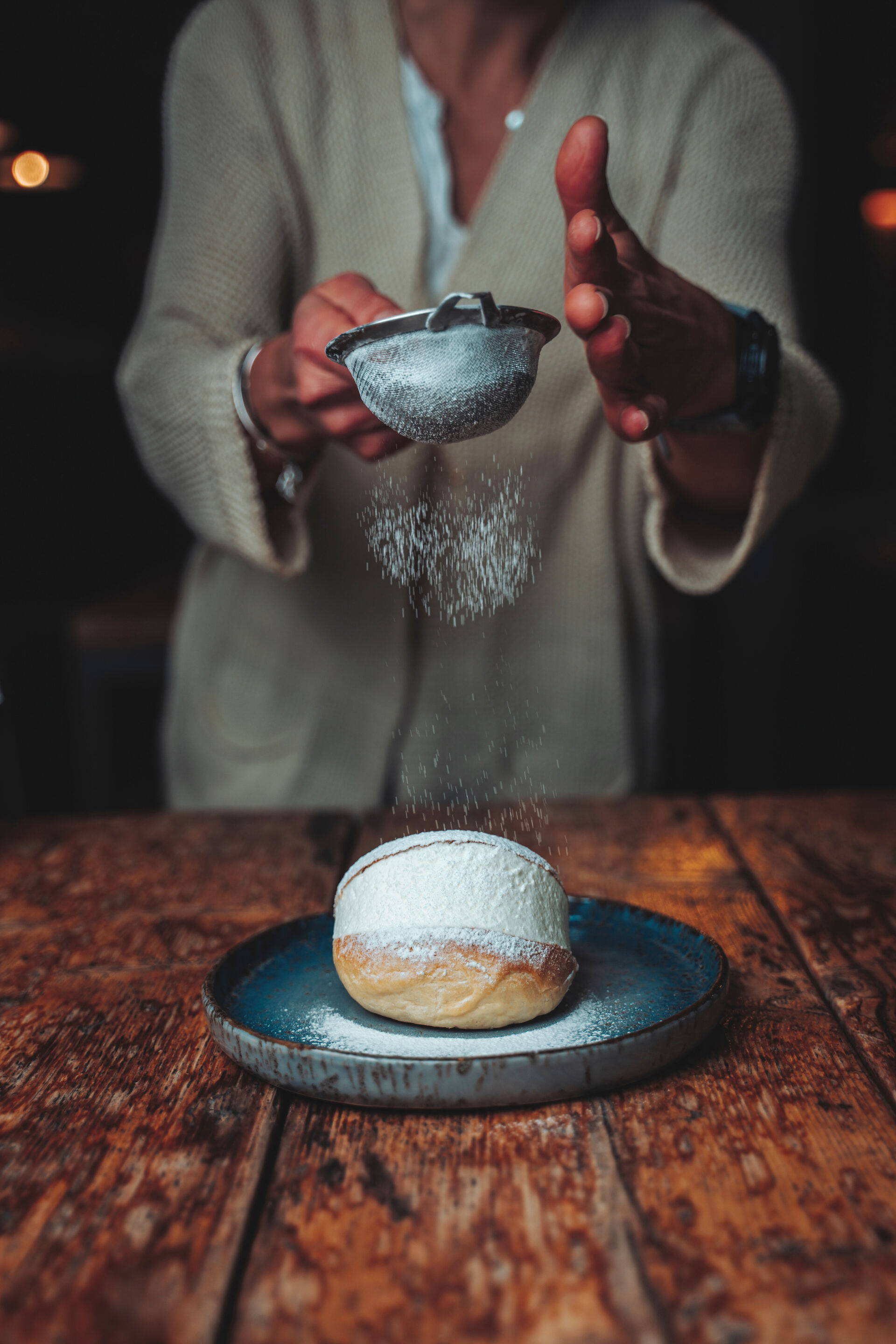 Bombolone spolverato di zucchero a velo su un piatto in ceramica